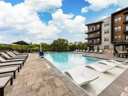 a swimming pool at a hotel with lounge chairs at Luxurious New Unit 2Bd2Ba Pool, Golf Sim in Austin