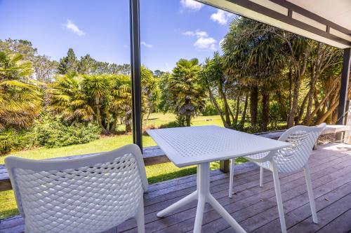 a white table and two chairs on a porch at Northridge Golf Resort in Orewa