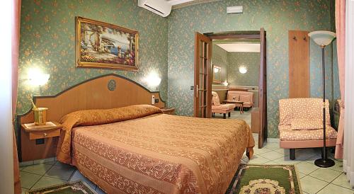 a bedroom with a bed and a chair in a room at Hotel Nespolo D'Oro in Lariano