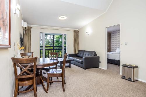 a living room with a table and chairs and a couch at Northridge Golf Resort in Orewa