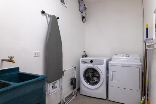 a laundry room with a washing machine and a sink at Stylish Oasis Retreat with Modern Amenities & Scenic Views in San Rafael