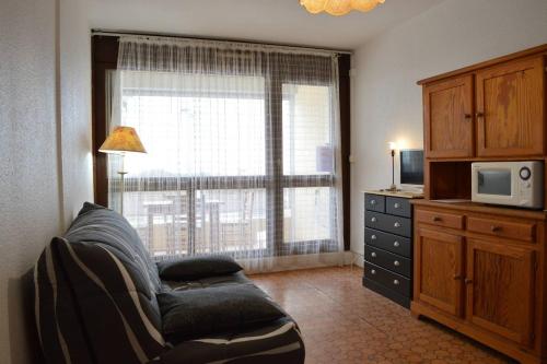 un salon avec un canapé et une grande fenêtre dans l'établissement SP150-007 Studio 2 couchages SAINT PIERRE LA MER, à Saint Pierre La Mer