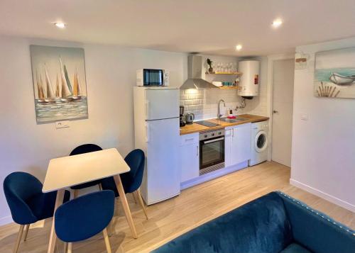 a kitchen with a blue couch and a table and chairs at 2 bedroom Albir apartment by the beach in Albir