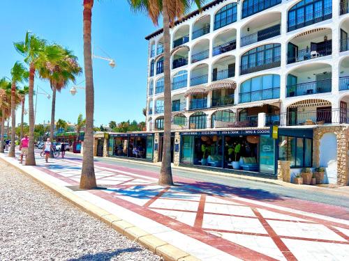 a large building with palm trees in front of it at 2 bedroom Albir apartment by the beach in Albir
