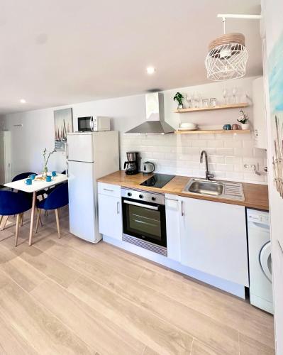 a kitchen with white appliances and a small table at 2 bedroom Albir apartment by the beach in Albir