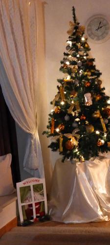 a christmas tree in a living room next to a chair at Il Rifugio della Quiete in Scicli
