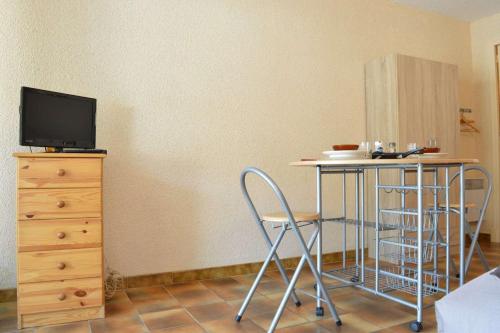 une pièce avec une table, des chaises et une télévision dans l'établissement SP230-005 Studio 2 couchages SAINT PIERRE LA MER, à Saint Pierre La Mer