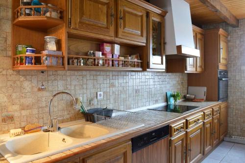 une cuisine avec des armoires en bois et un évier dans l'établissement SP270-001 Maison 4 pièces SAINT PIERRE LA MER, à Saint Pierre La Mer