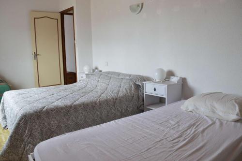 - une chambre blanche avec 2 lits et un miroir dans l'établissement SP270-001 Maison 4 pièces SAINT PIERRE LA MER, à Saint Pierre La Mer