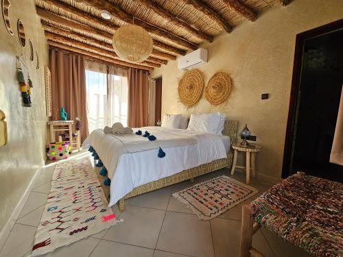 a bedroom with a large bed and a large window at Kasbah La Cigogne in Aït Ben Haddou