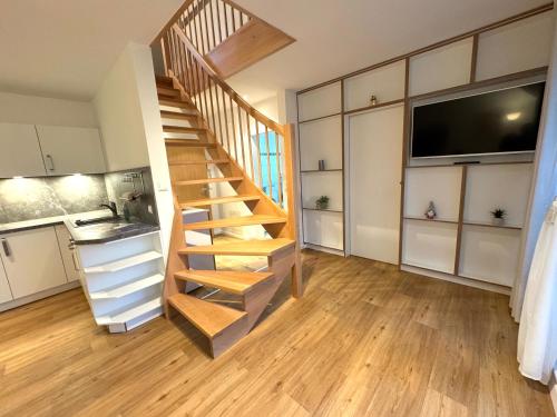 a wooden staircase in a room with a kitchen at K14 FeWo - Am Kurpark - Therme in Bad Saarow