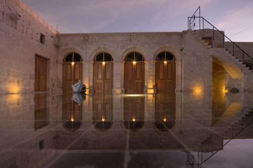 a building with a staircase and lights in the water at Palacio Guaqui by Ananay Hotels in Arequipa