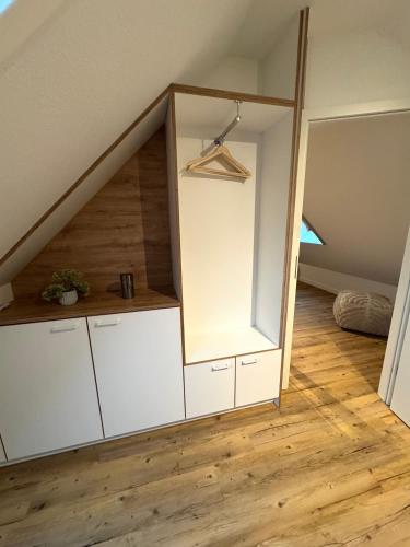 an attic room with white cabinets and a staircase at K14 FeWo - Am Kurpark - Therme in Bad Saarow