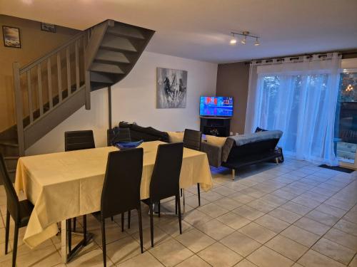 a living room with a table and chairs and a staircase at Un Brin de Mistral in Saint-Louis-du-Rhône