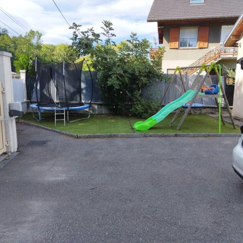 une aire de jeux avec un toboggan et une balançoire dans l'établissement Villa T5 proche centre ville, à Aix-les-Bains