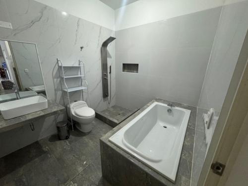 a bathroom with a tub and a toilet and a sink at LA CASA de DERY EN MANCORA in Máncora