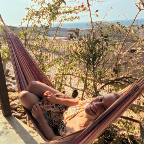a woman laying in a hammock on the beach at Punta Vichayo - Casa Ballenas in Talara