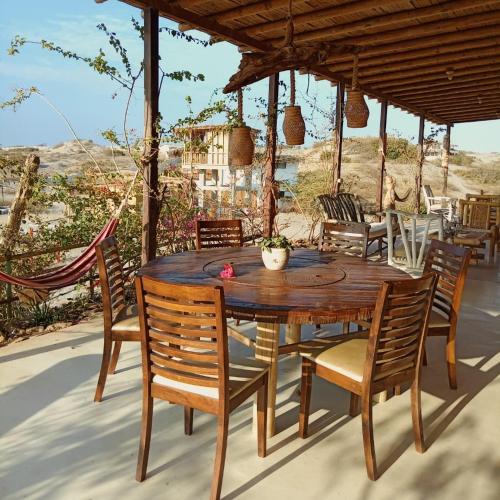 a wooden table and chairs on a patio at Punta Vichayo - Casa Ballenas in Talara