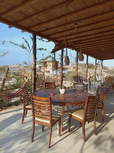 a wooden table and chairs on a patio at Punta Vichayo - Casa Ballenas in Talara