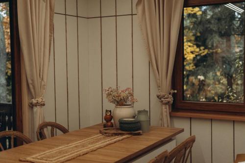 a dining room table with a vase of flowers on it at Jutowa Chata - nocleg bliżej natury in Łask