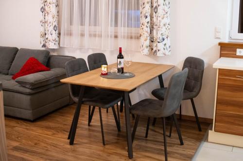 a dining room table with a bottle of wine on it at Appartment Elfi in Uttendorf