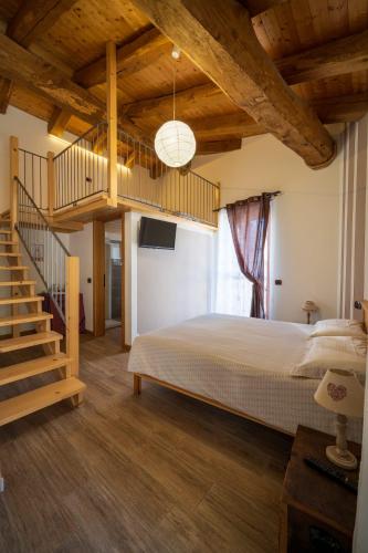 a bedroom with a large bed and a staircase at Affittacamere La Lea in Roccaforte Mondovì