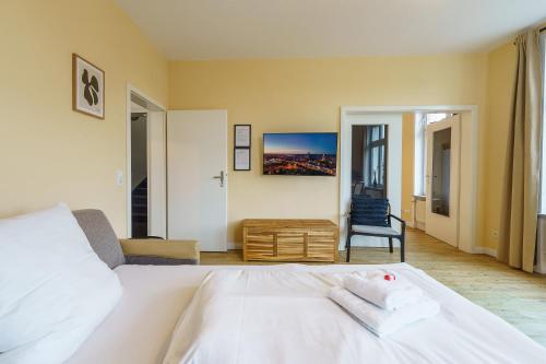 a bedroom with a white bed and a chair at Apartment mit Wasserblick in Lübeck