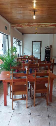 a dining room with wooden tables and benches at Alisson Hotel y Restaurant in Monteverde Costa Rica