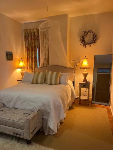 a bedroom with a large white bed with two lamps at The Happy House in New Orleans