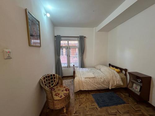 a bedroom with a bed and a window at Yoga Apartment Near Airport & Pashupatinath 2 BHK in Kathmandu