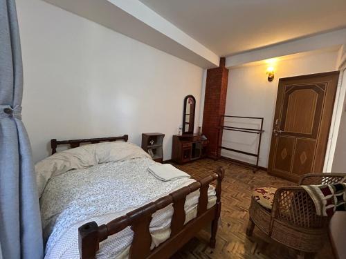 a bedroom with a bed and a chair in it at Yoga Apartment Near Airport & Pashupatinath 2 BHK in Kathmandu