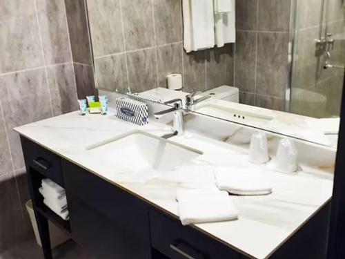 a bathroom with a sink and a mirror at Survivor Samoa Beach Resort in Falelatai