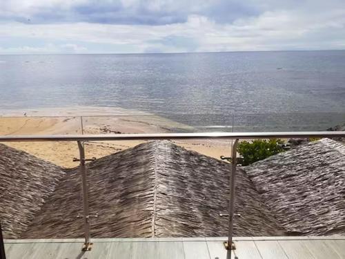 a view of a beach from a balcony with the ocean at Survivor Samoa Beach Resort in Falelatai