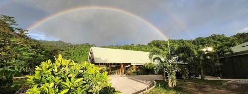 a rainbow in the sky over a house at Survivor Samoa Beach Resort in Falelatai
