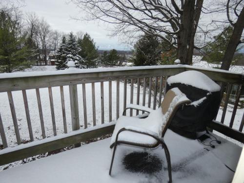 a bench covered in snow next to a fence at CrossWinds Getaway at Shanty Creek in Bellaire