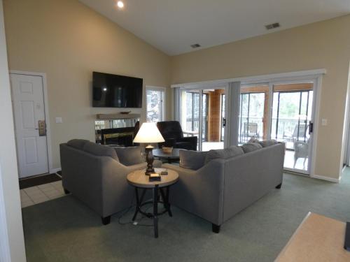 a living room with couches and a table with a lamp at CrossWinds Getaway at Shanty Creek in Bellaire