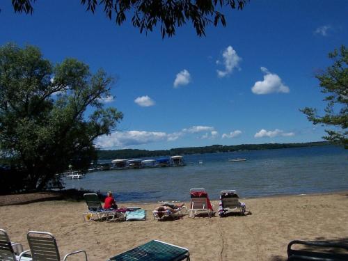 a beach with chairs and people sitting on the sand at CrossWinds Getaway at Shanty Creek in Bellaire