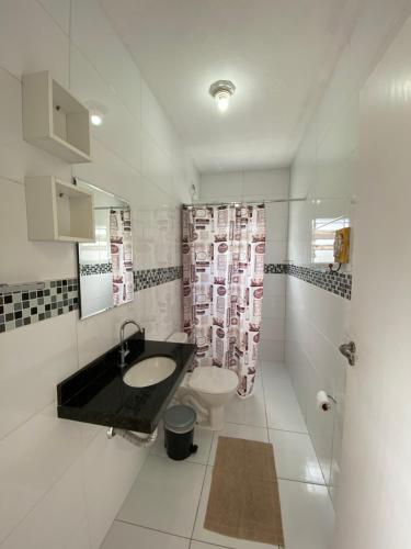 a bathroom with a sink and a toilet at Suítes Itapoã in Ubatuba