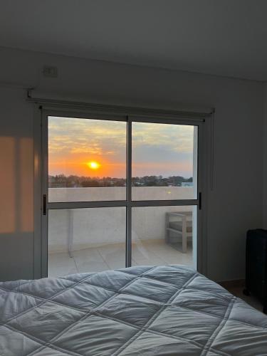 a bedroom with a bed and a view of the sunset at Apartamento Paris con 2 habitaciones in San Luis