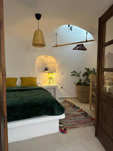a bedroom with a bed and a table and a lamp at Anedosa Cave House in Santorini