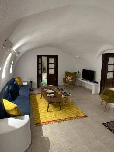 a living room with a blue couch and a table at Anedosa Cave House in Santorini