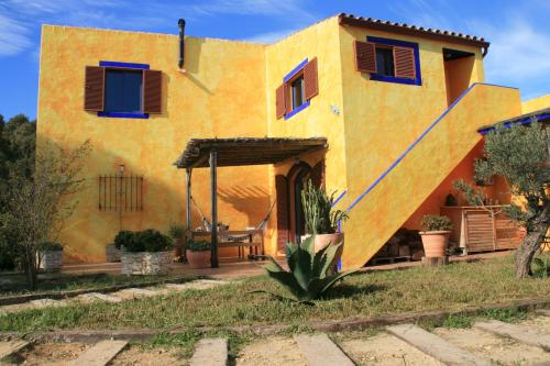 gelbes Haus mit blauen Fensterläden und einer Veranda in der Unterkunft El Vuelo de la Libélula in Barbate