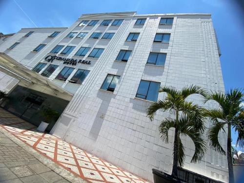 a tall building with a palm tree in front of it at TAMA Hotel Granada Real Cali in Cali