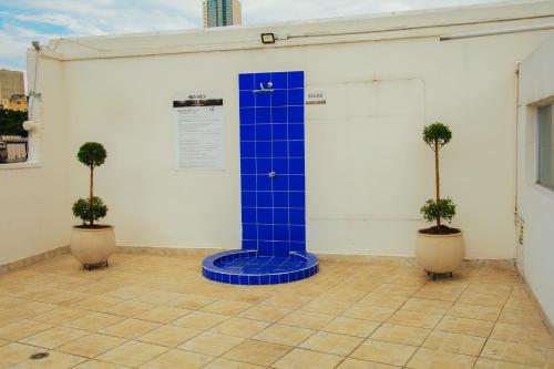 a blue pillar in a room with two potted plants at TAMA Hotel Granada Real Cali in Cali