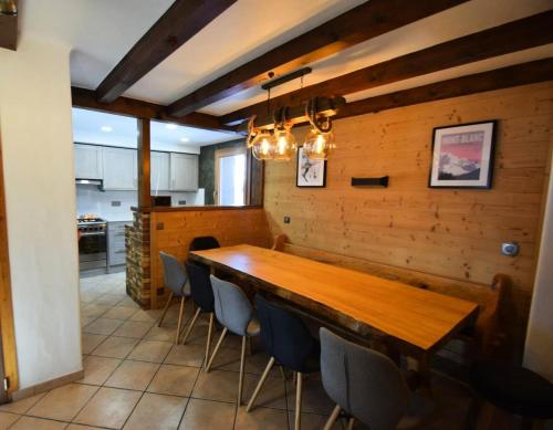 une salle à manger avec une table et des chaises en bois dans l'établissement Chalet Le Becoin - CHALET MITOYEN 10/12 pers - 100m des pistes SAUNA- WIFI - PLAGNE 1800 MAE-6654, à Aime La Plagne