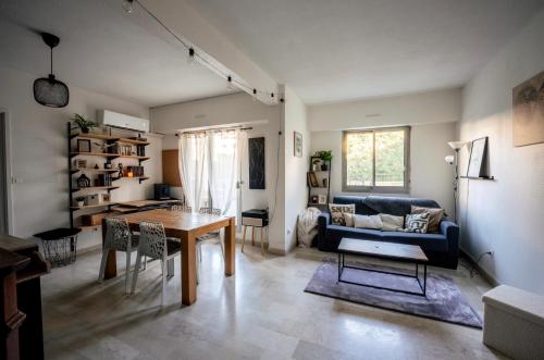 un salon avec une table et un canapé dans l'établissement T2 Cosy proche du centre avec grande terrasse!, à Nîmes