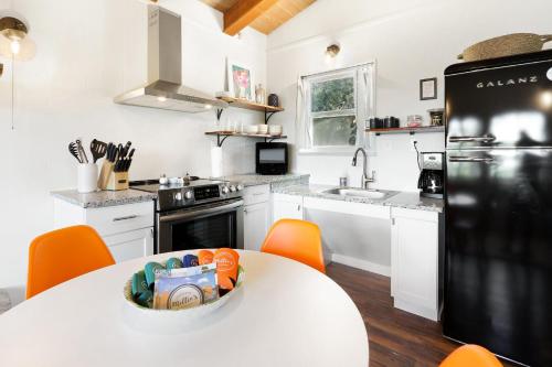 a kitchen with a white table and a black refrigerator at Millie's Cottages Unit 1 - Ruth in Canyon Lake
