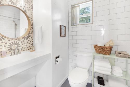 a white bathroom with a toilet and a mirror at Millie's Cottages Unit 1 - Ruth in Canyon Lake