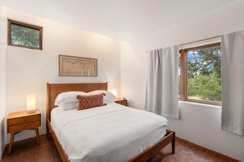 a white bedroom with a bed and a window at Casa de Flechas in Santa Fe NM in Santa Fe