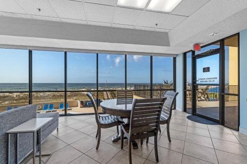 a dining room with a table and chairs and the ocean at Phoenix V 902 in Orange Beach